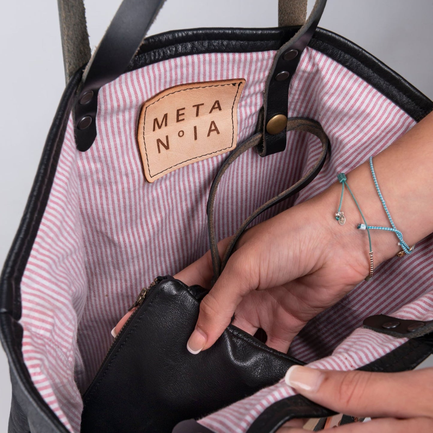 METANoIA The Cross Medium Bag inside featuring pinstripe fabric sourced from recycled fabric and a caramel leather woven label lasered with the iconic METANoIA label.