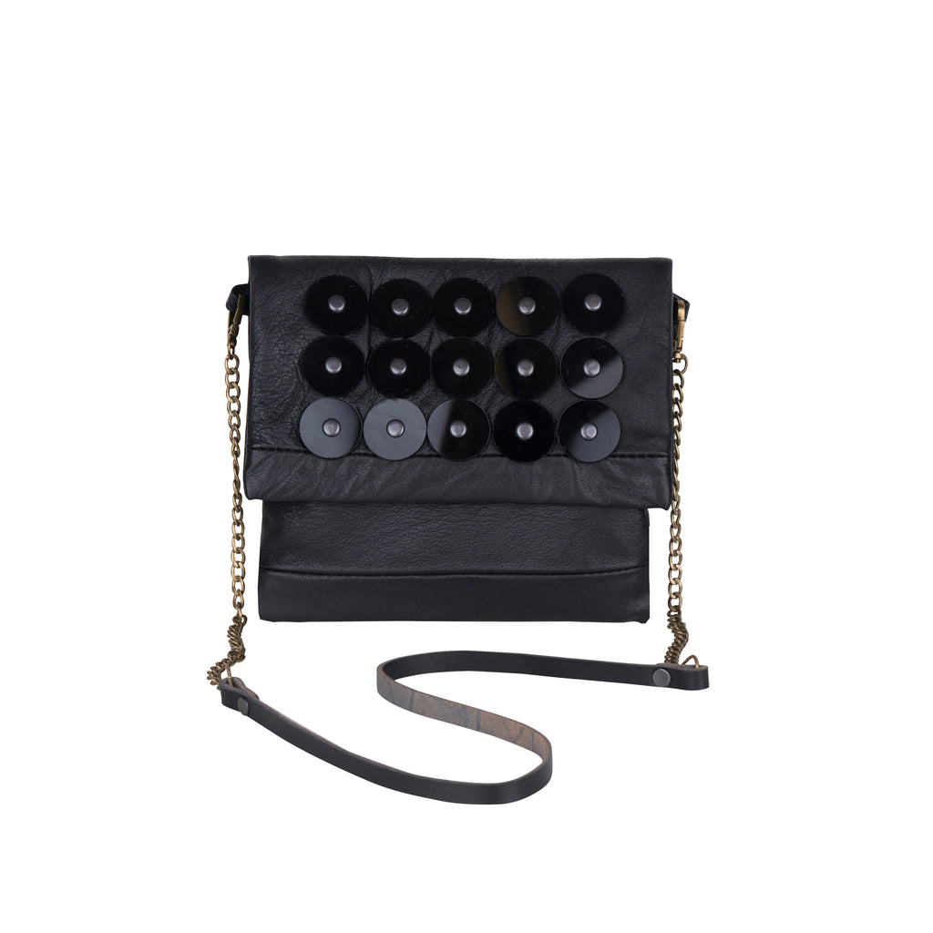 METANoIA black recycled leather small handbag with black circle acrylic forms fashioned into a repeative fashion with a smaller circle overlay on each form. 