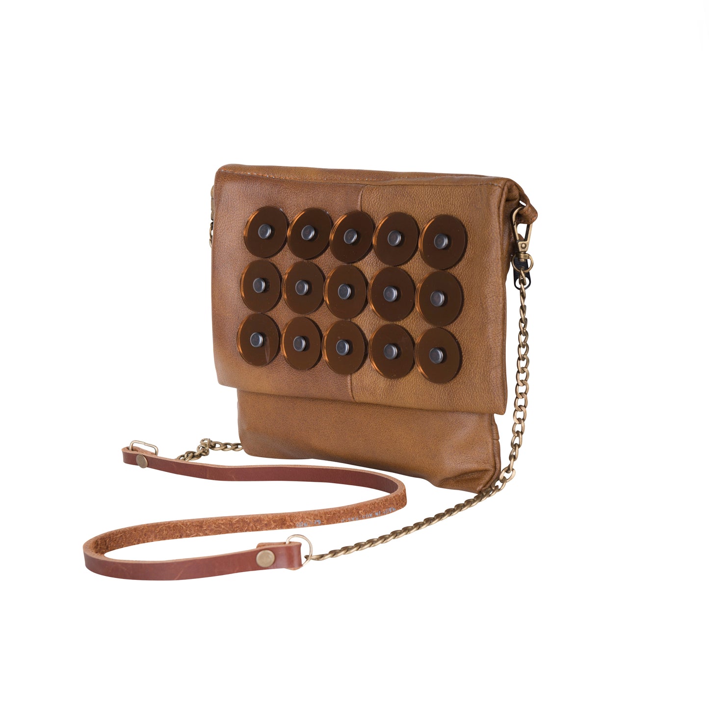 METANoIA tan recycled leather small handbag with circle copper acrylic forms fashioned into a repeative fashion with a smaller circle overlay on each form placed at a sideview.