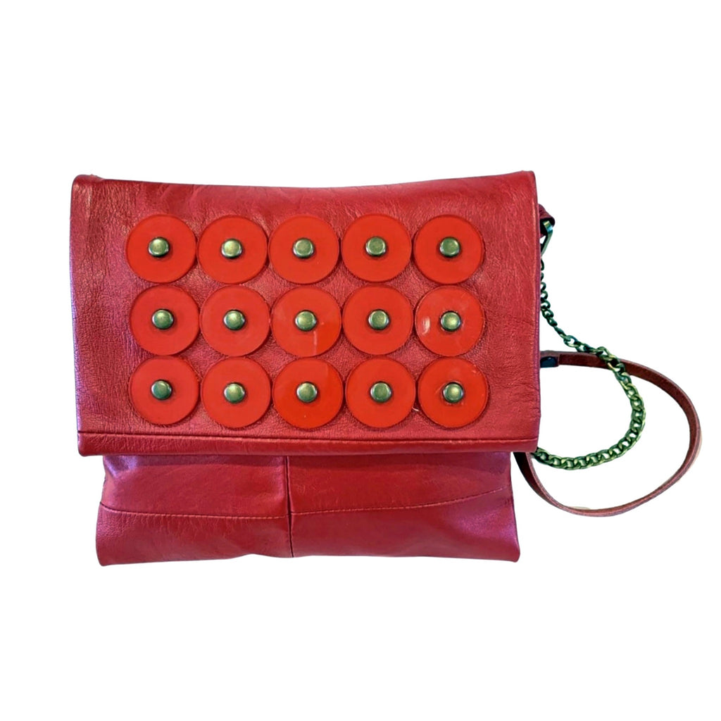 METANoIA red recycled leather small handbag with circle red acrylic forms fashioned into a repeative fashion with a smaller circle overlay on each form. 