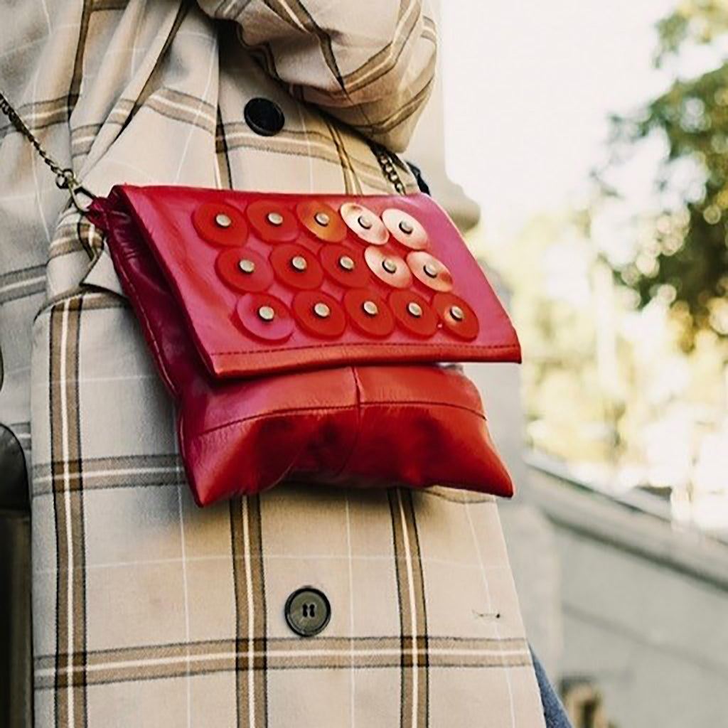 METANoIA red recycled leather small handbag with circle red acrylic forms fashioned into a repeative fashion with a smaller circle overlay on each form. 