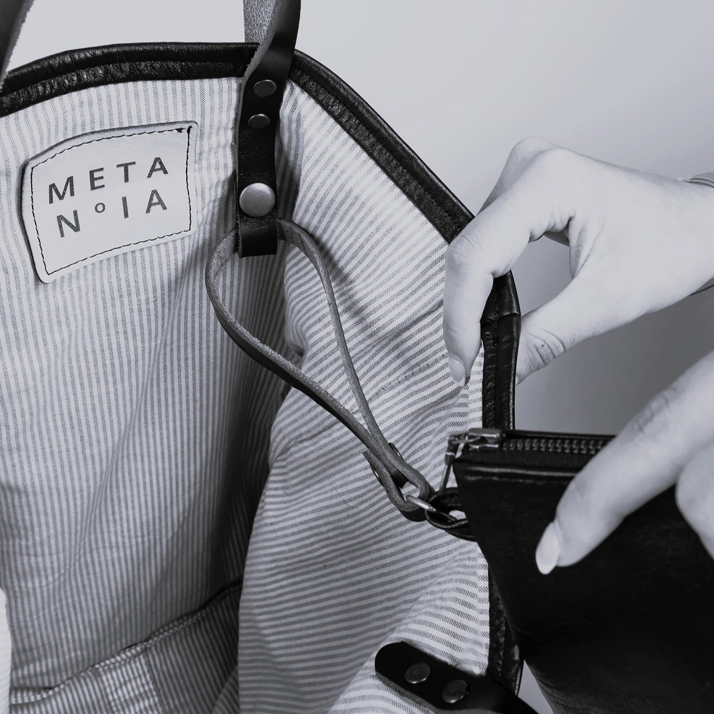 METANoIA The Cross Tote inside featuring pinstripe fabric sourced from recycled fabric and a caramel leather woven label lasered with the iconic METANoIA label.