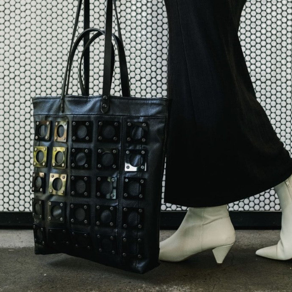METANoIA black recycled leather tote handbag with square and hollowed circle bamboo and walnut acrylic forms fashioned into a repeative fashion. 